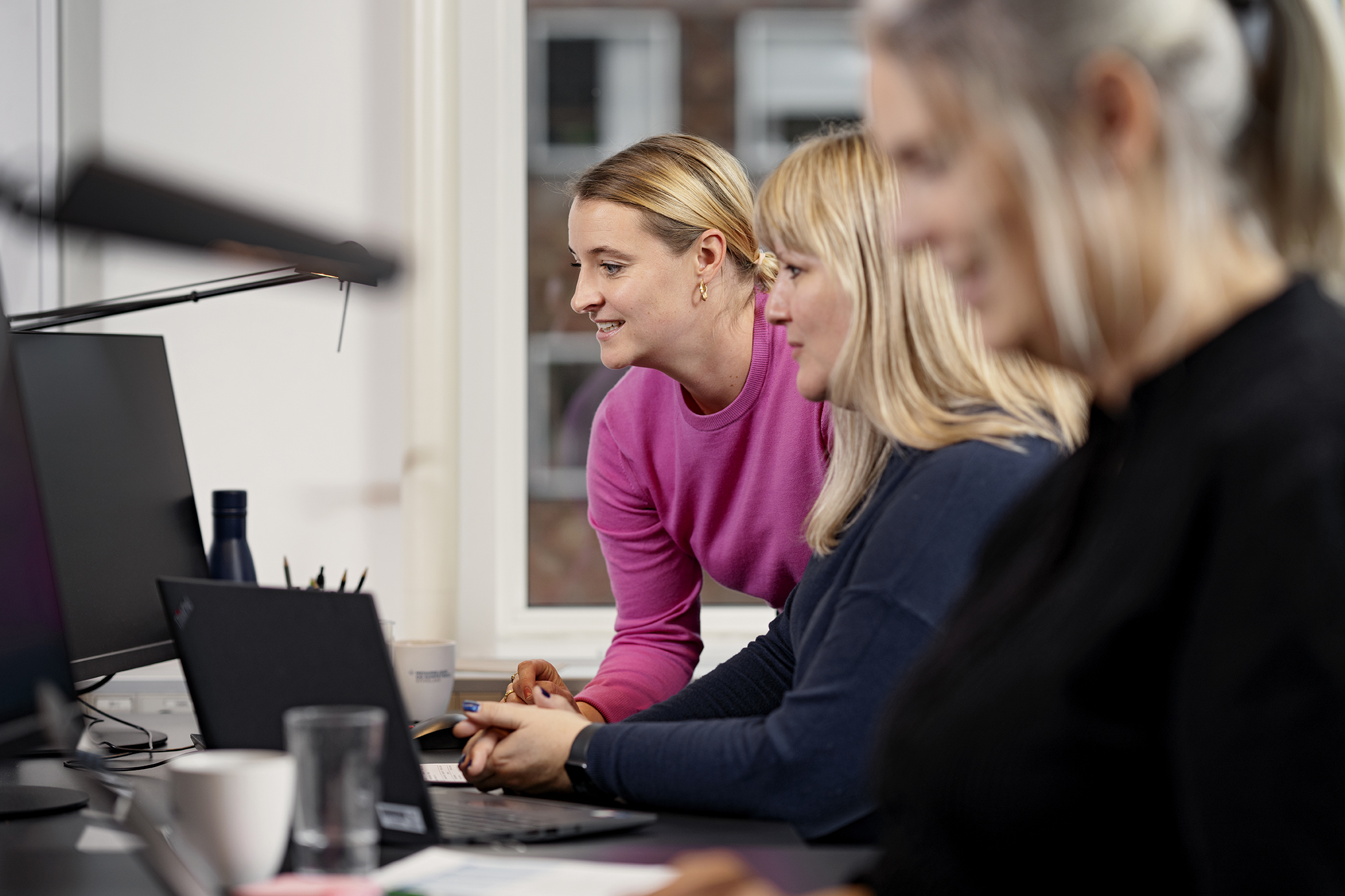 Medarbejder hjælper kollega på computer